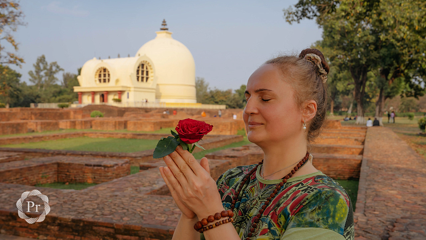 woman holding a rose in her hands doing namaste